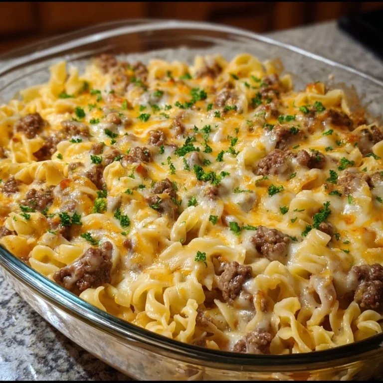 Cheesy beef noodle casserole topped with melted cheese and herbs in a baking dish